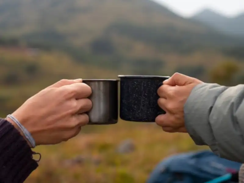 Café en la montaña Pareja brindando con café en la montaña